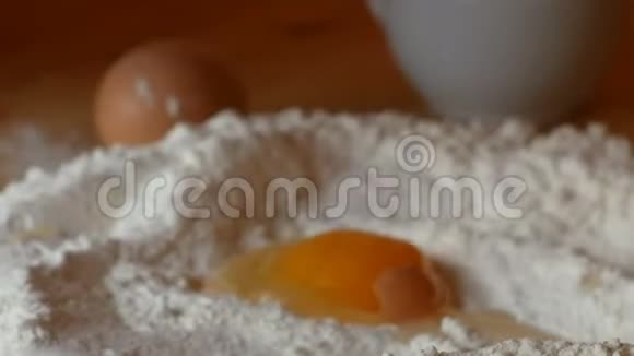 老妇人把鸡蛋倒在面粉上视频的预览图
