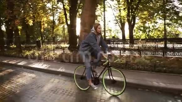 美丽的白种人女性骑自行车在早晨公园或大道一个年轻女子骑着徒步旅行的侧面景色视频的预览图