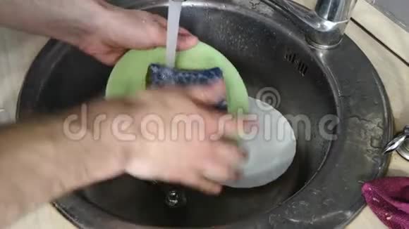 房子里的人用手在流水特写下洗碗视频的预览图