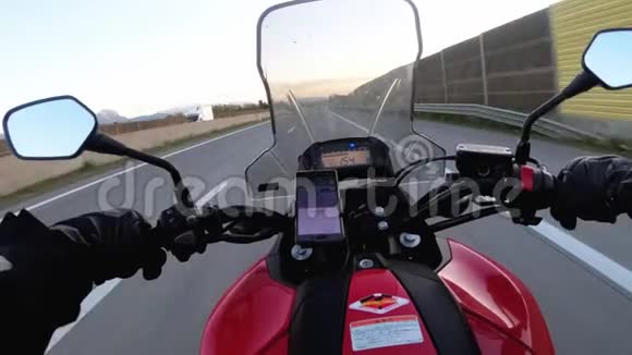 摩托车手在高速公路上驾驶从车轮后面看风景视频的预览图