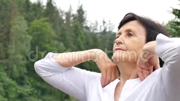 一位留着深色短发的老年妇女早上在户外做伸展运动以放松自己视频的预览图