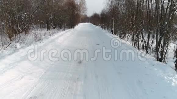 冬季道路上覆盖着雪空中镜头相机慢慢向后移动视频的预览图