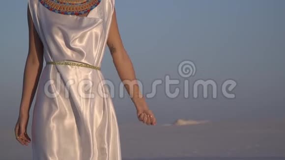 埃及伟大的纹身女王站在天空的背景下释放出一把沙子慢动作视频的预览图
