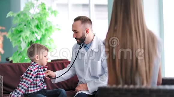 儿童患者用听诊器穿白色实验室外套的男性儿科医生视频的预览图