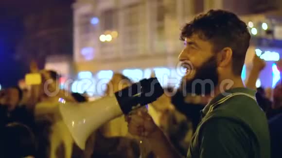 一个穿着绿色T恤的男人在一次街头聚会上开始对着喊声唱歌视频的预览图