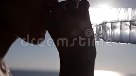 女人在海边的水瓶里喝酒视频的预览图