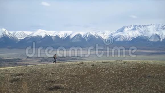 背包旅行的极端旅行者沿着山区平原行走积极的生活方式视频的预览图