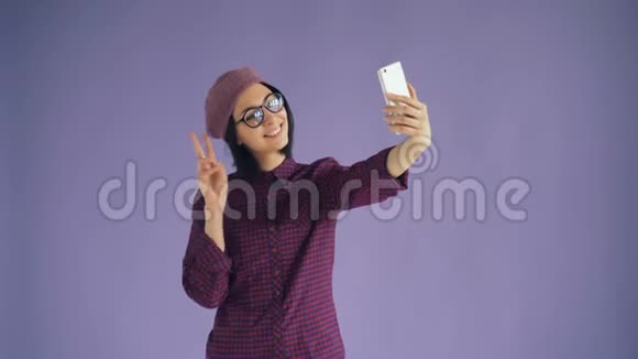 玩味的年轻女人用智能手机相机自拍的肖像视频的预览图