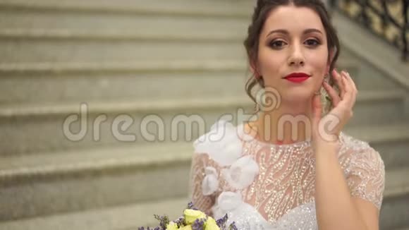 一位新娘穿着婚纱在台阶上房间里的肖像视频的预览图