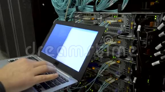 工程师在服务器室笔记本电脑在光学服务器的背景上闪烁灯技术员视频的预览图
