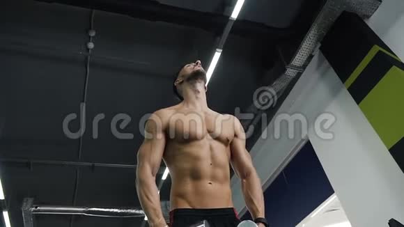 一个年轻的运动员在健身房里用哑铃抽胳膊肌肉视频的预览图