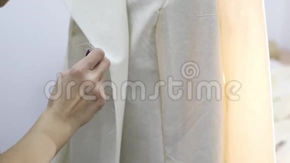 裁缝师用缝纫针在裁剪的初始阶段把夹克扎上视频的预览图