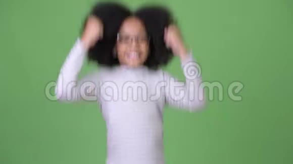 年轻可爱的非洲女孩一头非洲头发跳跃时看上去很开心很兴奋视频的预览图