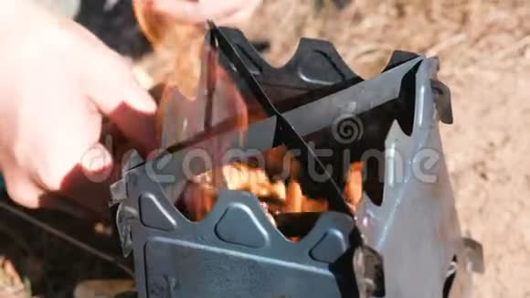 人们在室外的树林里点燃金属炉炉男人双手特写上景视频的预览图