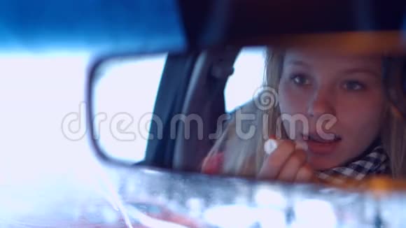 车轮后的女孩在后视镜里涂口红4K30fpsPros视频的预览图
