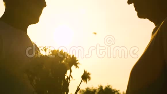 一对夫妇在夕阳的映衬下拥抱着视频的预览图