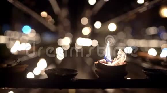 在佛教寺庙黑暗的内部燃烧油烛视频的预览图