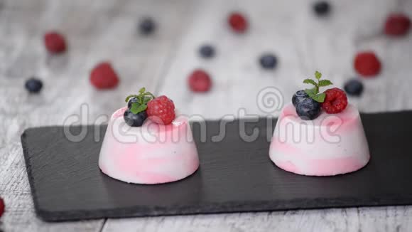 美味的浆果慕斯甜点以新鲜的覆盆子蓝莓和薄荷装饰视频的预览图