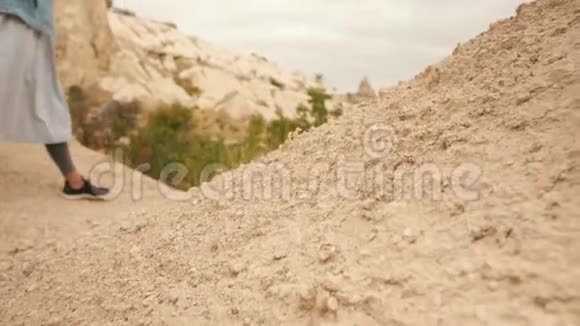 在土耳其卡帕多西亚年轻的混合种族旅游女孩用手机拍摄美丽的山岩照片4K慢动作视频的预览图