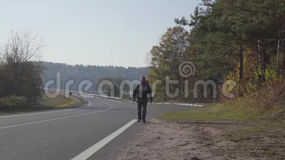 人正走在沥青路上背着一个背包秋景视频的预览图