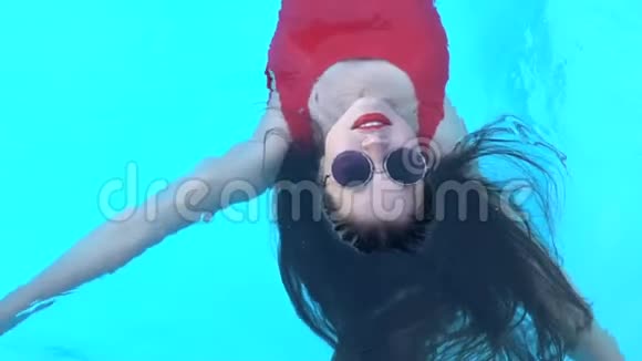 穿着红色泳衣的女士躺在水中享受新鲜的凉爽的水放松视频的预览图
