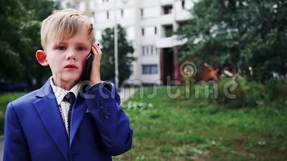 可爱的小男孩用大型智能手机说话视频的预览图