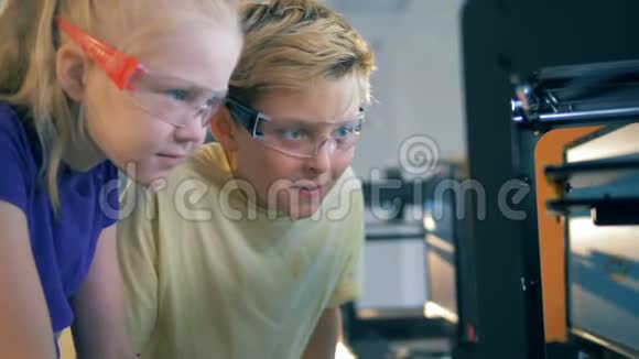 有3D打印机的antorium设备两个孩子在工作中观看视频的预览图