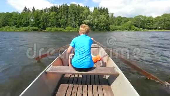 穿着救生衣的蓝色男孩腿上漂浮在船上发出刺耳的叫声坐金属船的年轻人视频的预览图