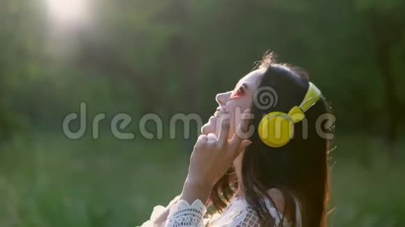 美丽的女孩在浪漫的形象听耳机与愉快的音乐视频的预览图