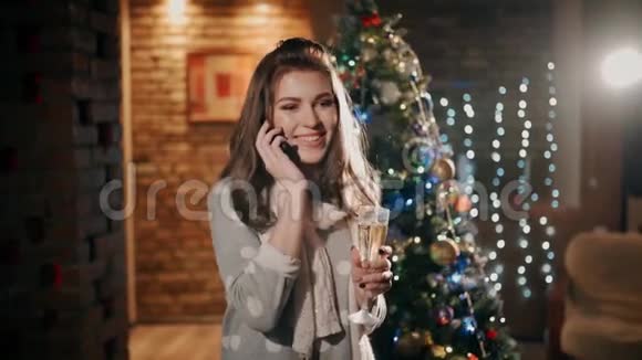 一个漂亮的女孩正在电话交谈在一个精心设计的客厅里喝着香槟视频的预览图