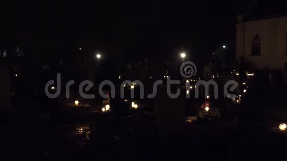 在所有圣徒之夜或万圣节期间点燃蜡烛人们参观墓地4K视频的预览图