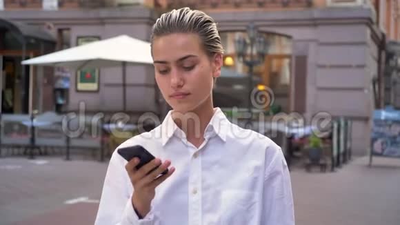 年轻的现代女性站在街上打电话接受预约沟通观念城市观念视频的预览图
