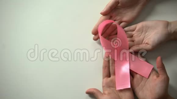 2月4日世界癌症日题字人们手里拿着粉红色的丝带视频的预览图