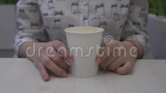 咖啡馆里的一个女孩正用手指敲打着一杯咖啡视频的预览图