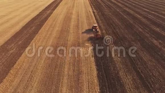 秋天一辆黄色的拖拉机穿过犁地视频的预览图