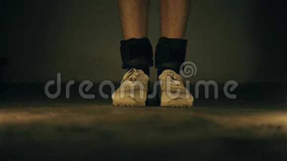 穿白色运动鞋和黑色脚踝负重的腿部特写镜头并进行增加视频的预览图