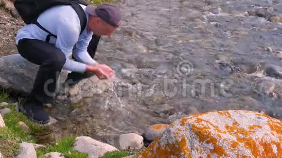 从山上的石河来的淡水洗脸的游客视频的预览图