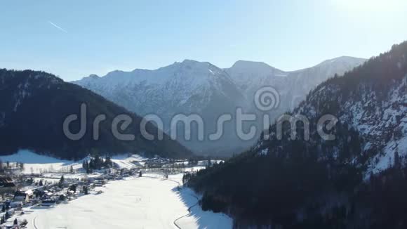 背景上覆盖着巨大雪山的小镇的空中镜头视频的预览图
