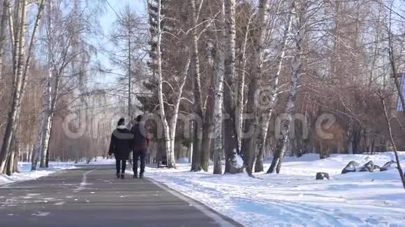 冬天男孩和女孩正穿过公园视频的预览图