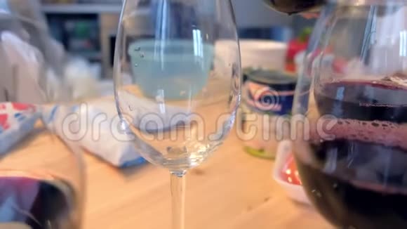在家里的厨房里红酒被倒进酒杯里视频的预览图