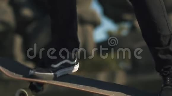 站在户外滑板上的运动鞋的腿部特写骑在滑板上慢动作爱好和爱好视频的预览图