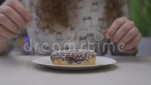 年轻的红发美女拿起一个巧克力甜甜圈视频的预览图