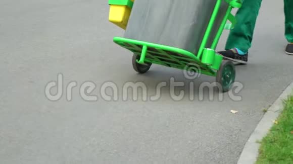 在车轮上用匀速滚动的垃圾桶清洗服务人员视频的预览图