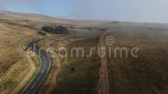 从空中俯瞰群山之间的空路有很多云雾的道路视频的预览图