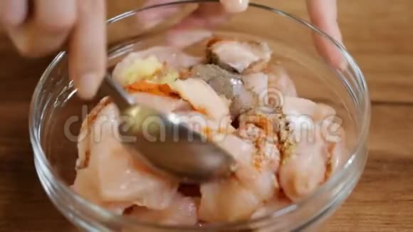 将生鸡放入碗中加入红辣椒和香料用香料在碗中腌制鸡肉的特写镜头视频的预览图