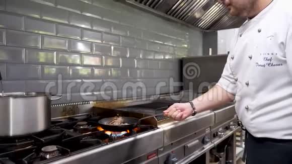 男厨师在餐厅的厨房里煎一块牛肉视频的预览图