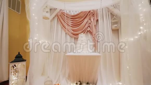 婚礼蛋糕用玫瑰装饰站在一张木桌上移动摄像机视频的预览图