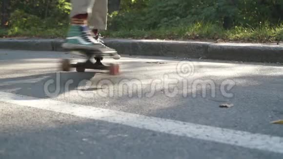 一个家伙在滑板上耍花招在滑板上滑的家伙的腿慢动作视频的预览图