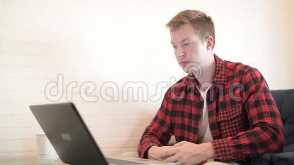年轻快乐的时髦男人一边喝咖啡一边在咖啡店思考视频的预览图