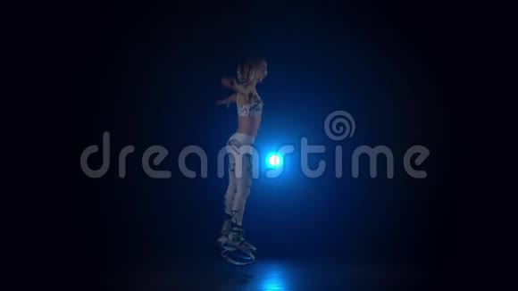 在kangoo跳舞的女性在蓝色聚光灯下跳鞋慢动作视频的预览图